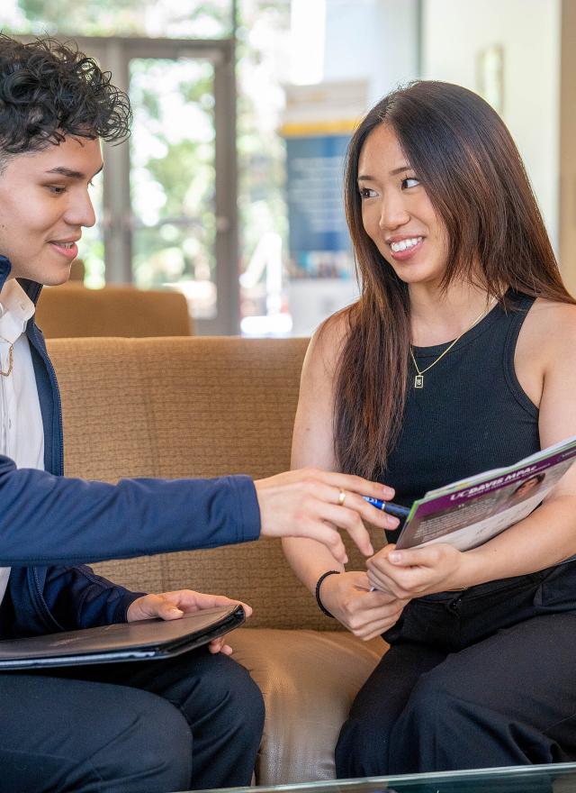 Two MPAc students reviewing a flyer in Gallagher Hall