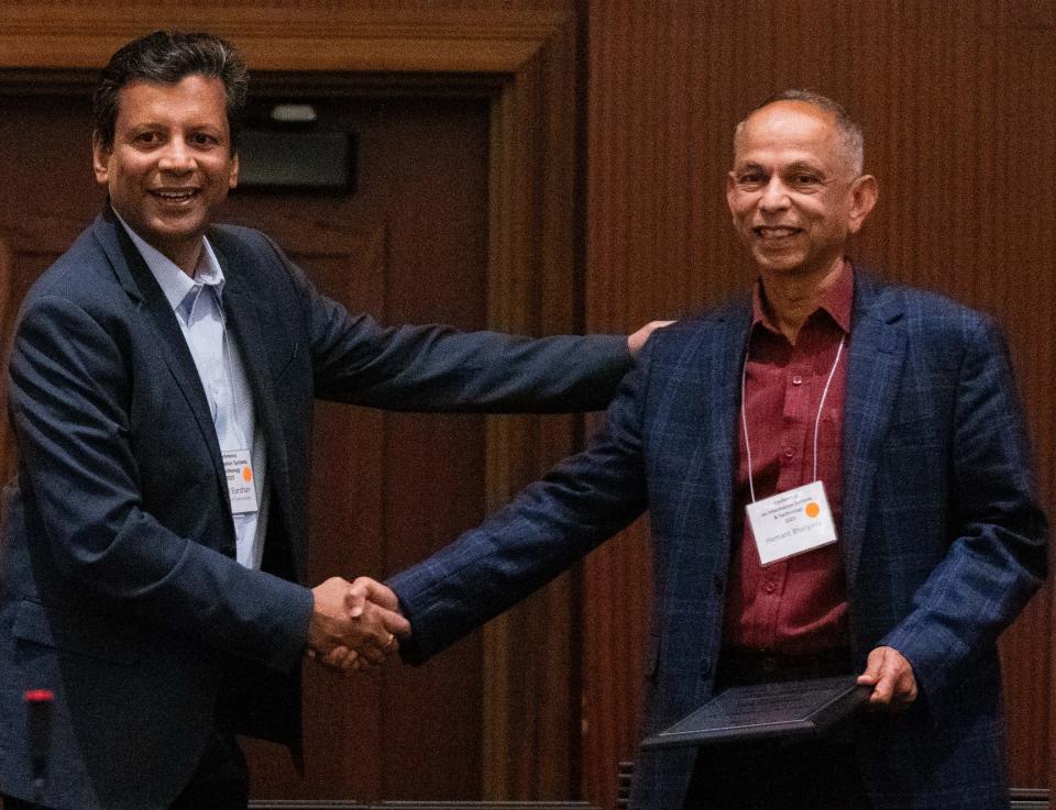 Distinguished Professor Hemant Bhargava (right) accepts the ISS President’s Service Award from Professor Indranil Bardhan