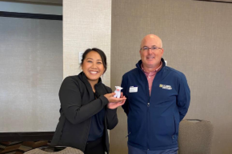 Kathy Truong holding up a UC Davis promotional cow with Brian Risi 