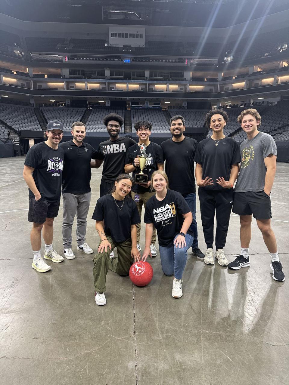 group of people posing with a trophy and dodgeball