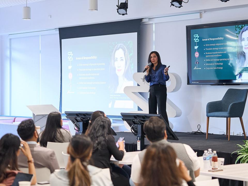 COO Daisy Hernandez on a stage, talking to students