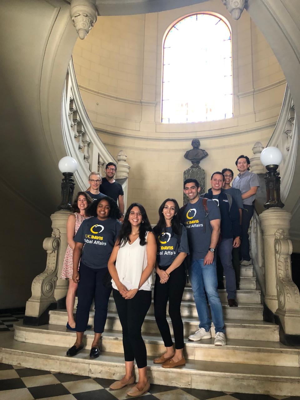 The UC Davis team and others pose for a photo on a staircase