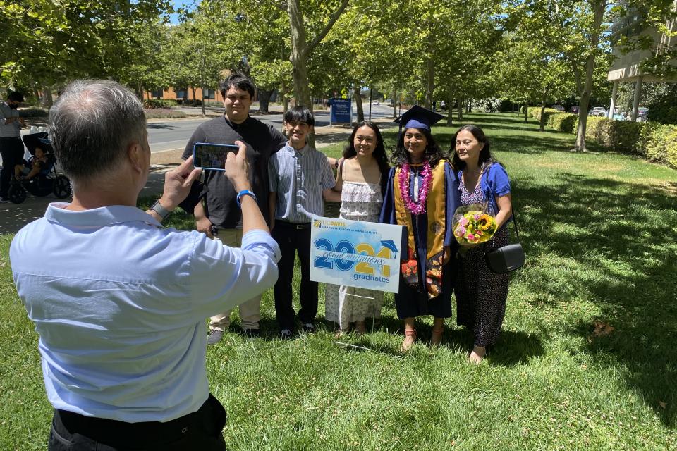 Jessica Padolina and family take a photo at Aggie Grad Walk